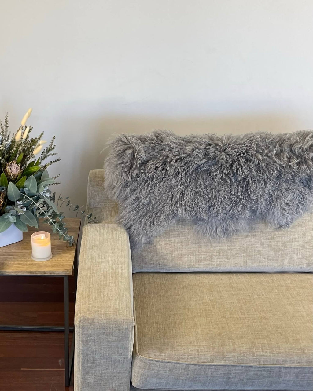 Grey Mongolian Sheepskin Rug draped on back of sofa