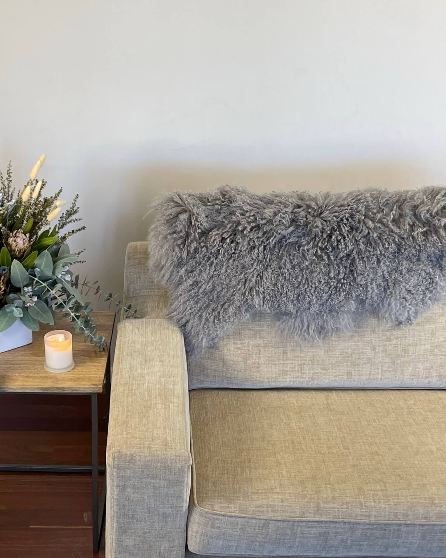 Grey Mongolian Sheepskin Rug draped on back of sofa