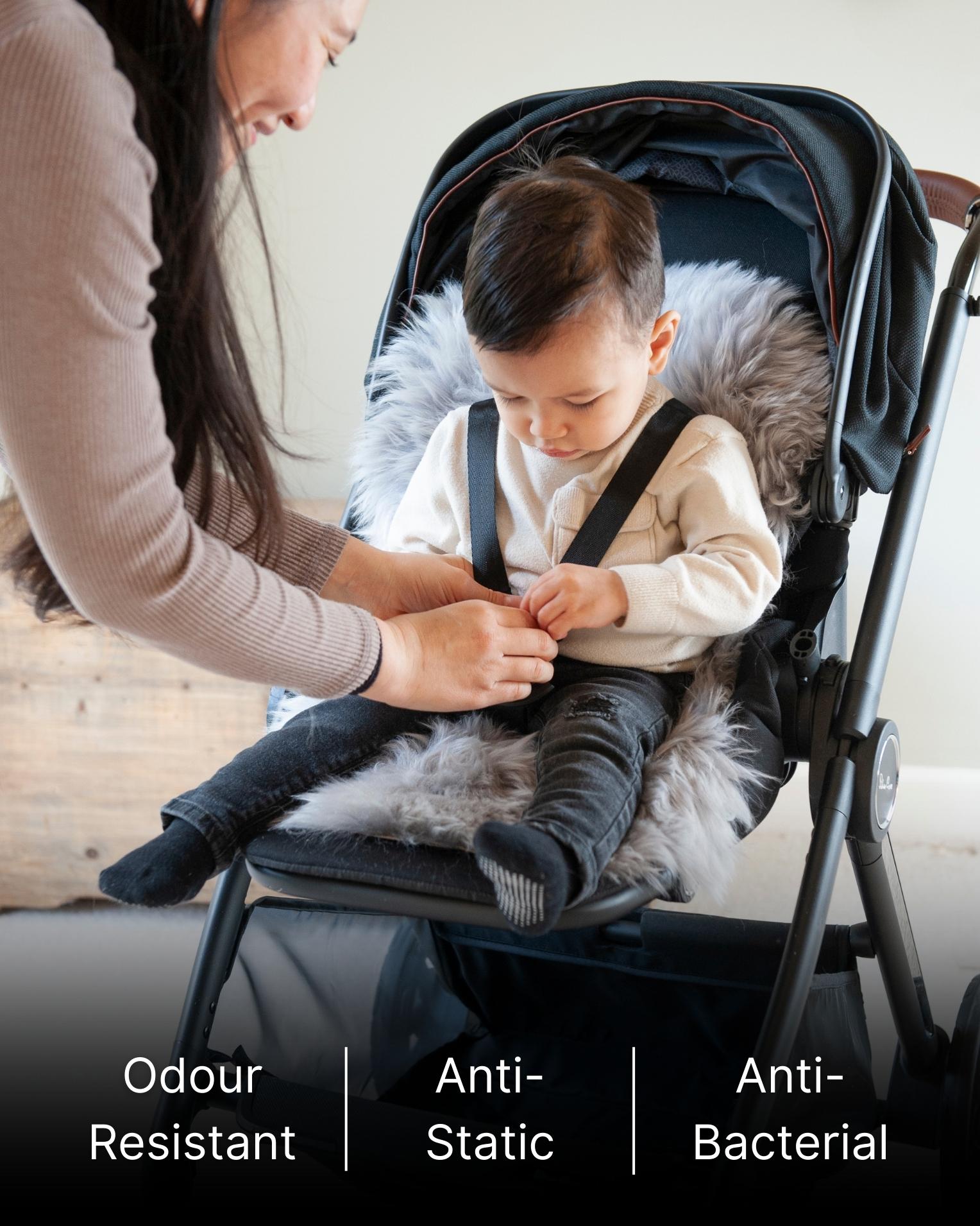 Child being buckled into a stroller