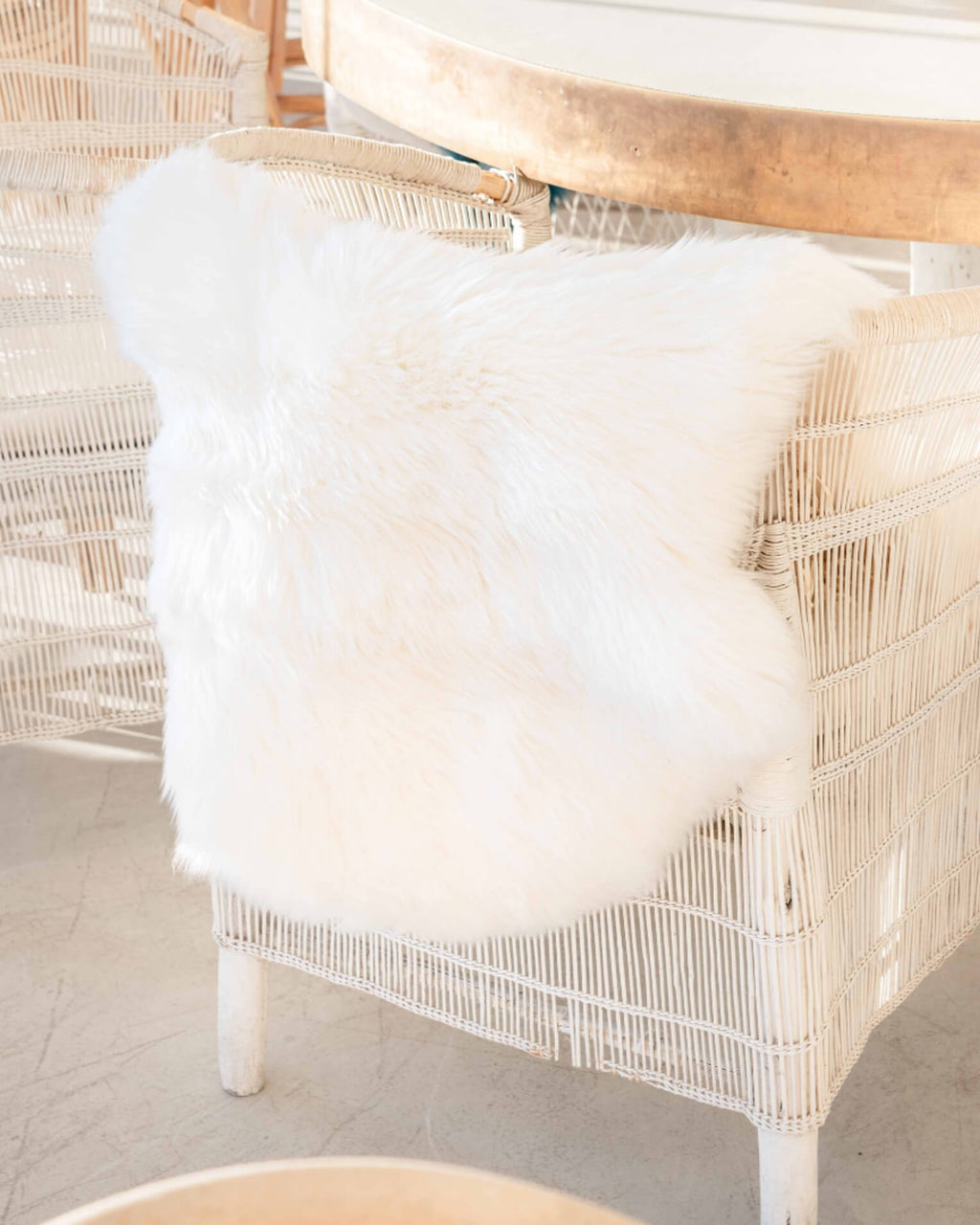 Ivory Single Sheepskin rug on white ratten chair