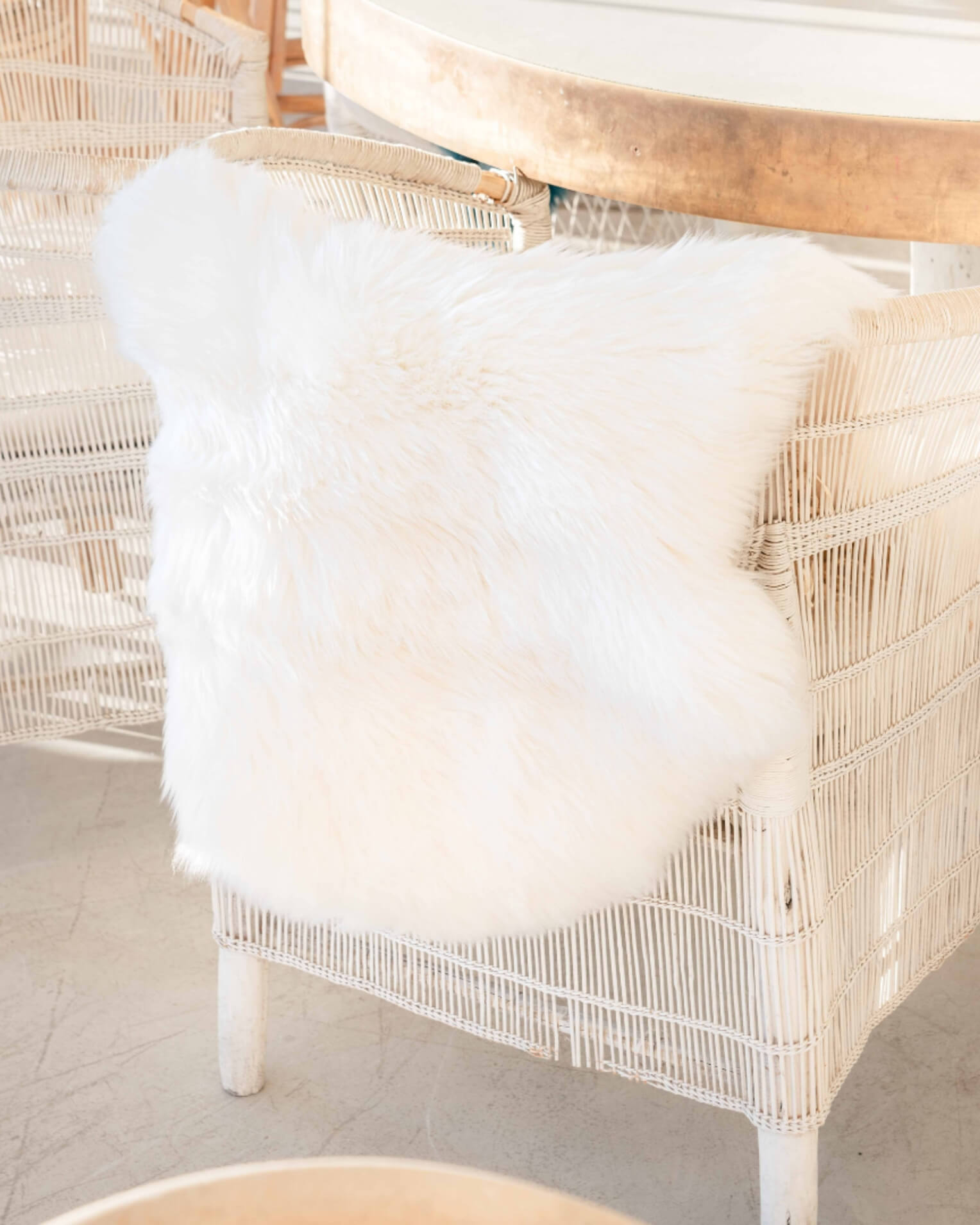 Ivory Single Sheepskin rug on white ratten chair