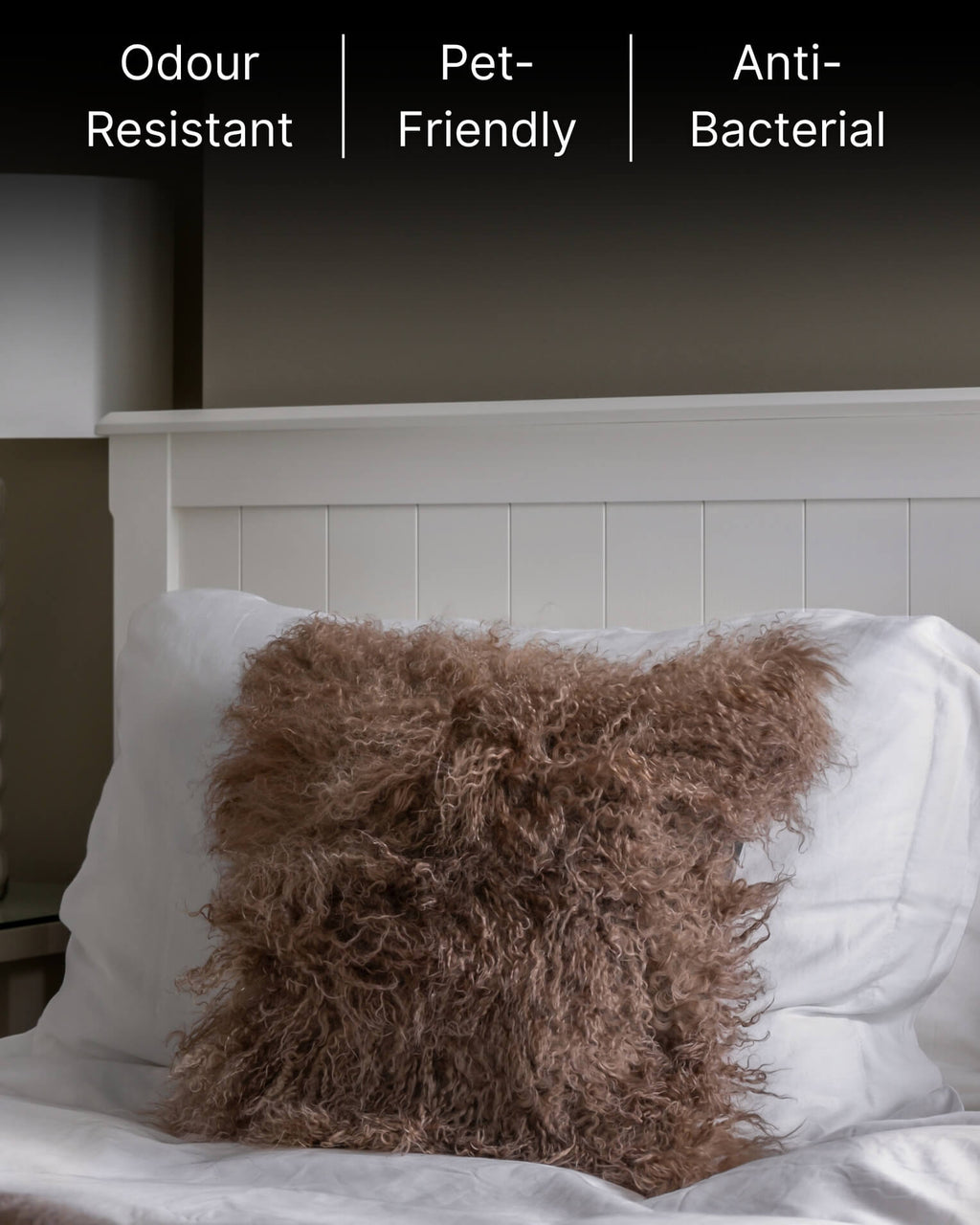 Mocha mongolian sheepskin pillow on white bed