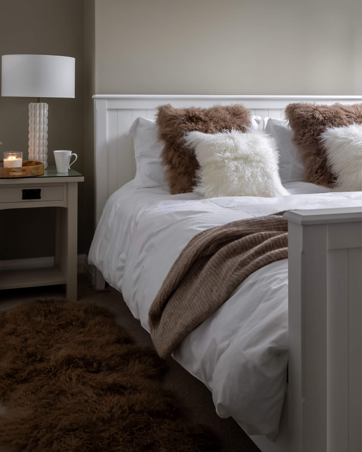 Bedroom with a bed featuring white bedding and brown and white pillows.