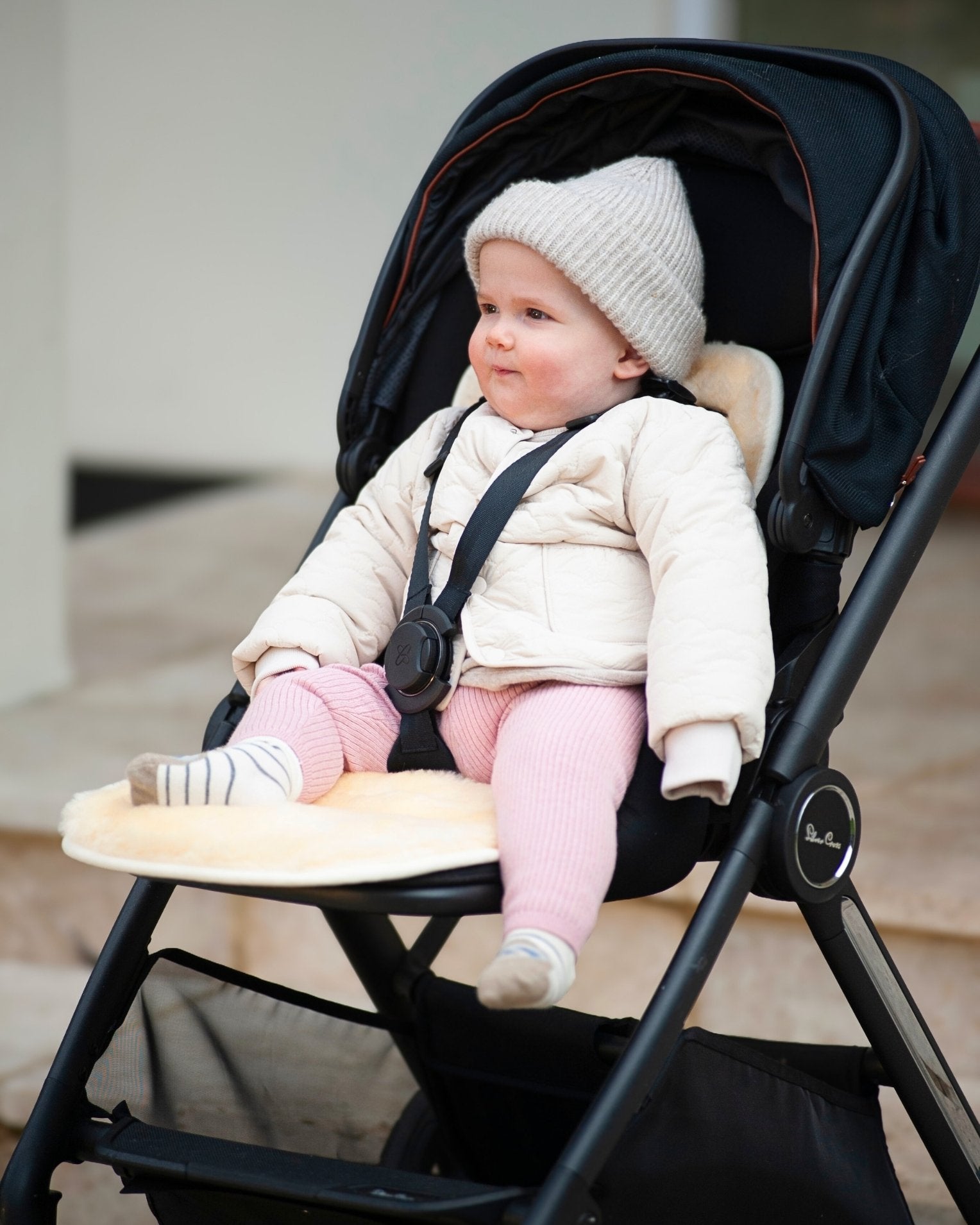 Baby in a stroller wearing a white coat