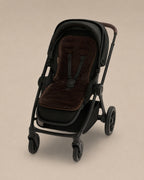 Black stroller with a Chocolate coloured sheepskins pram liner