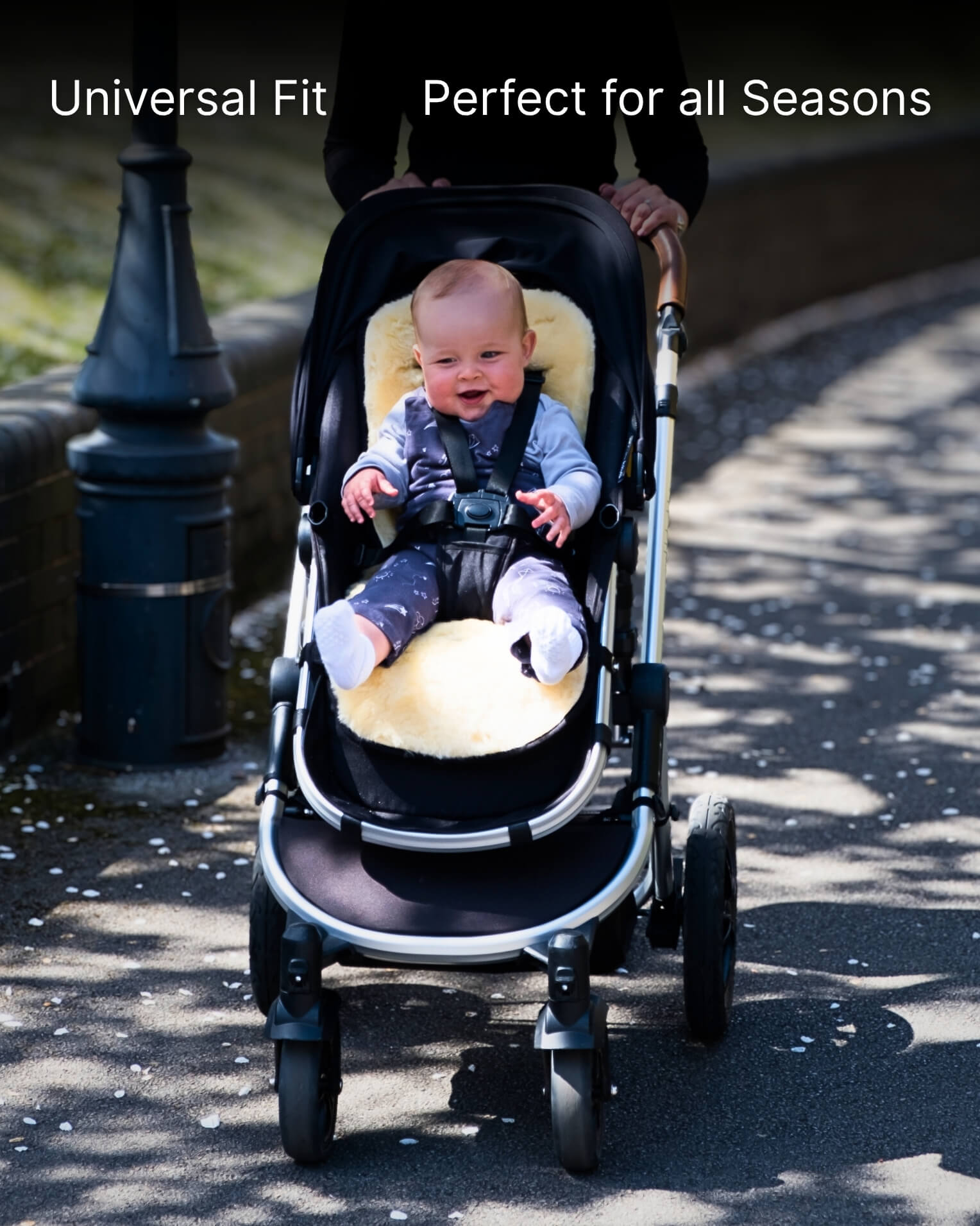 Baby in a stroller with white sheepskin pram liner