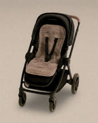 Black stroller with a grey sheepskins pram liner