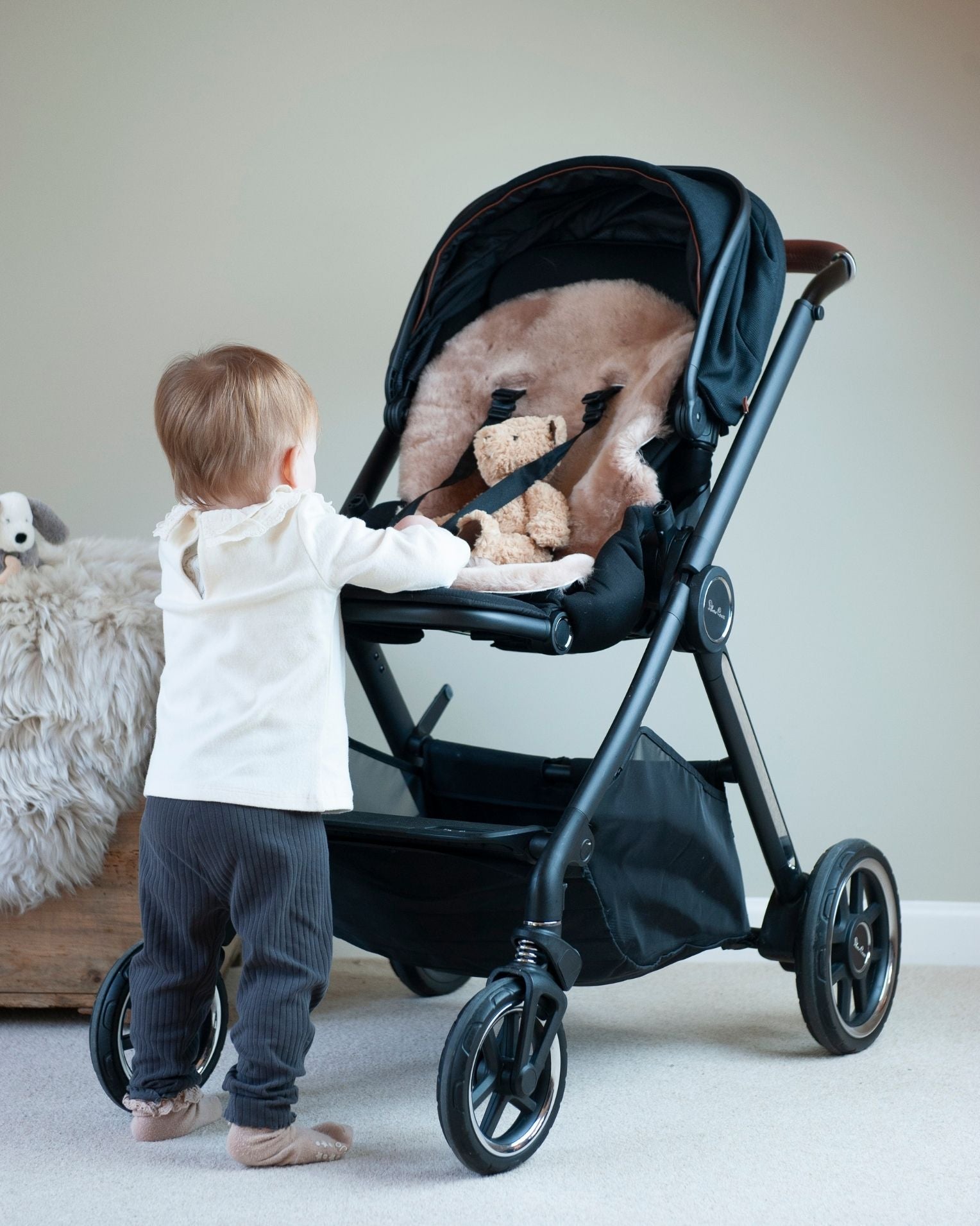 Child interacting with a black stroller