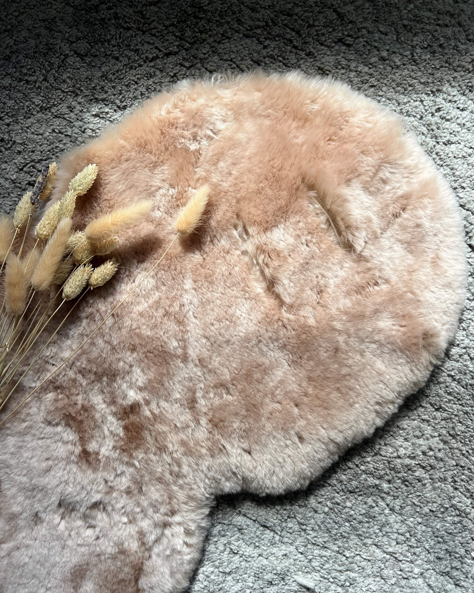 Round beige pram liner being used as a play mat