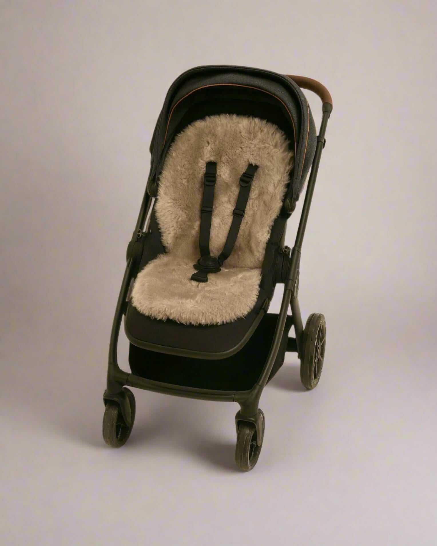 Black stroller with a beige sheepskin seat cover