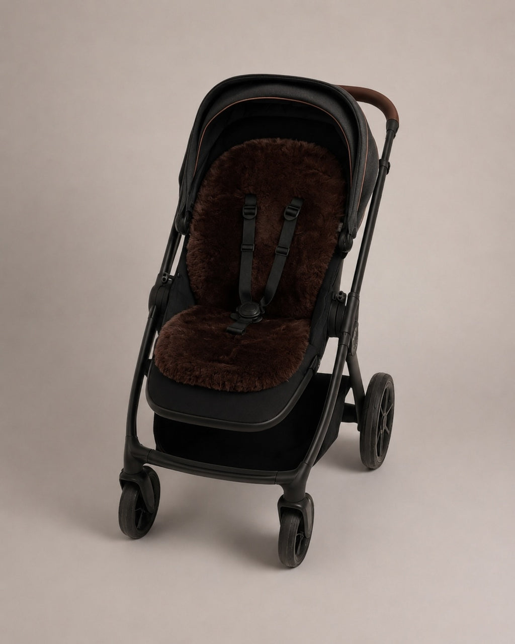 Black stroller with a chocolate coloured sheepskin seat cover