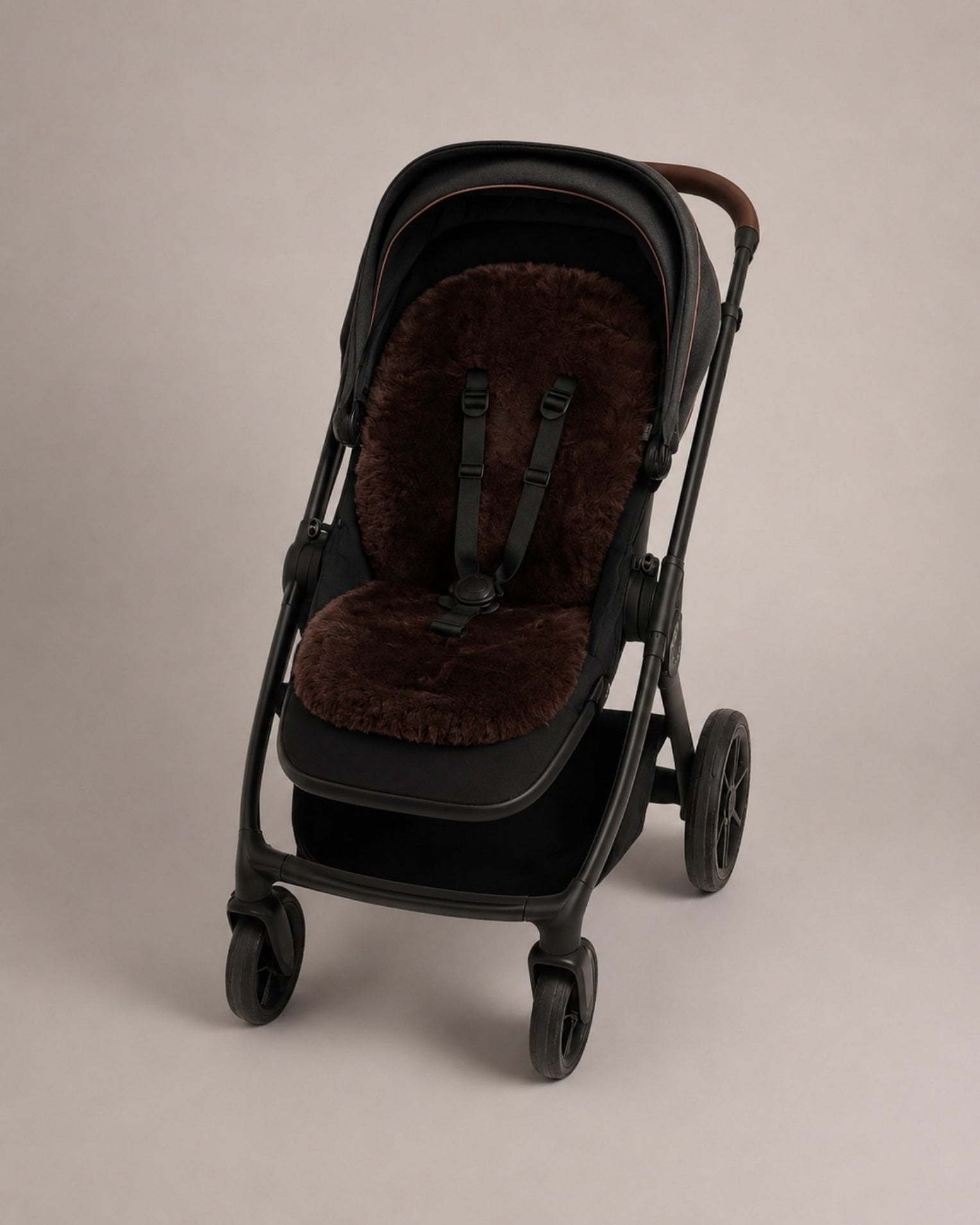 Black stroller with a chocolate coloured sheepskin seat cover