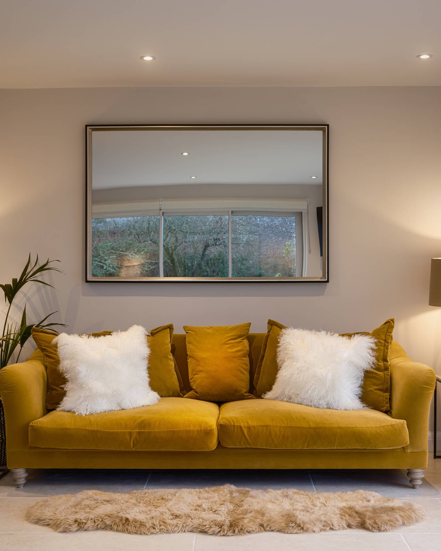 White mongolian sheepskin pillows on yellow sofa