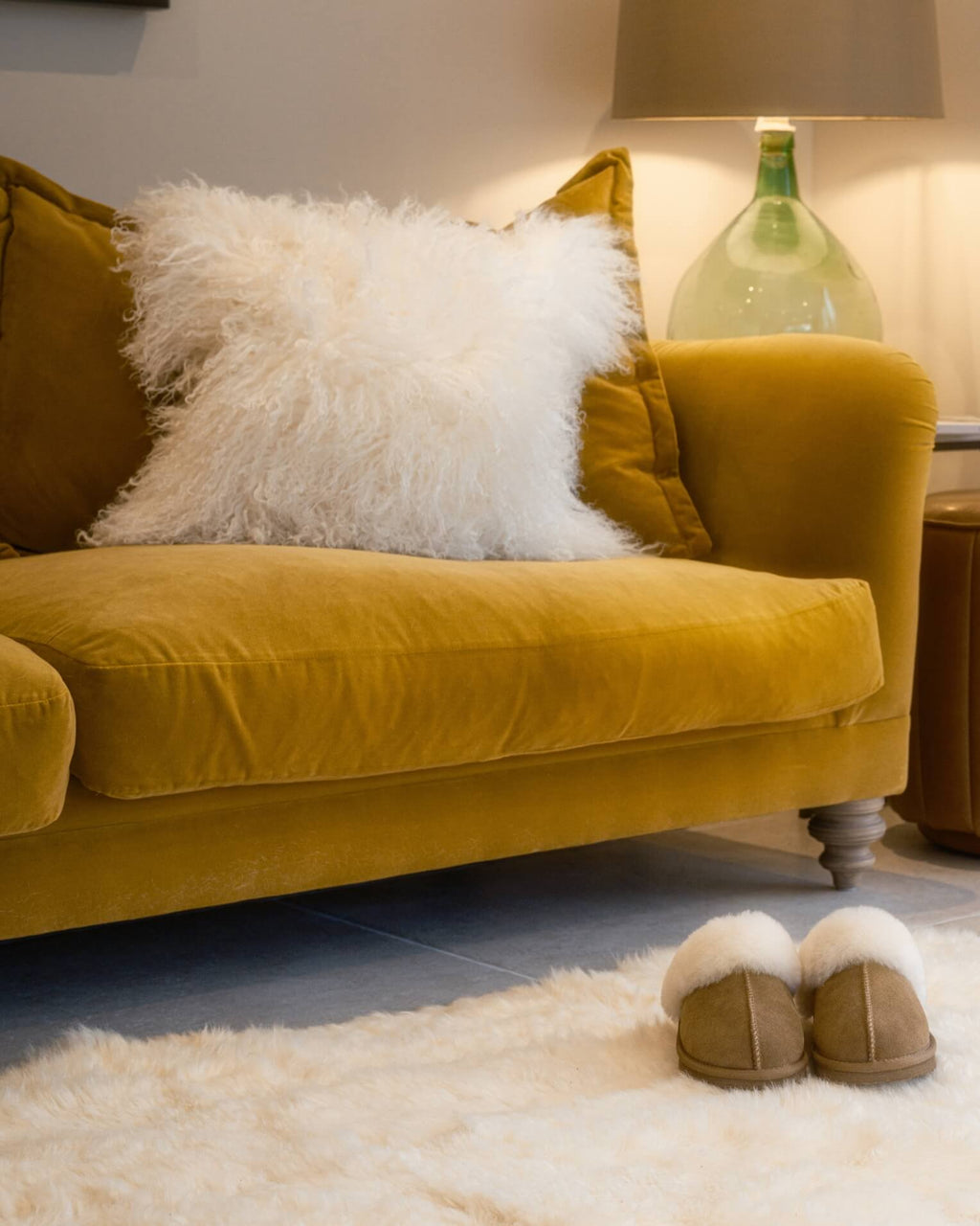 White mongolian sheepskin pillow on yellow sofa close up