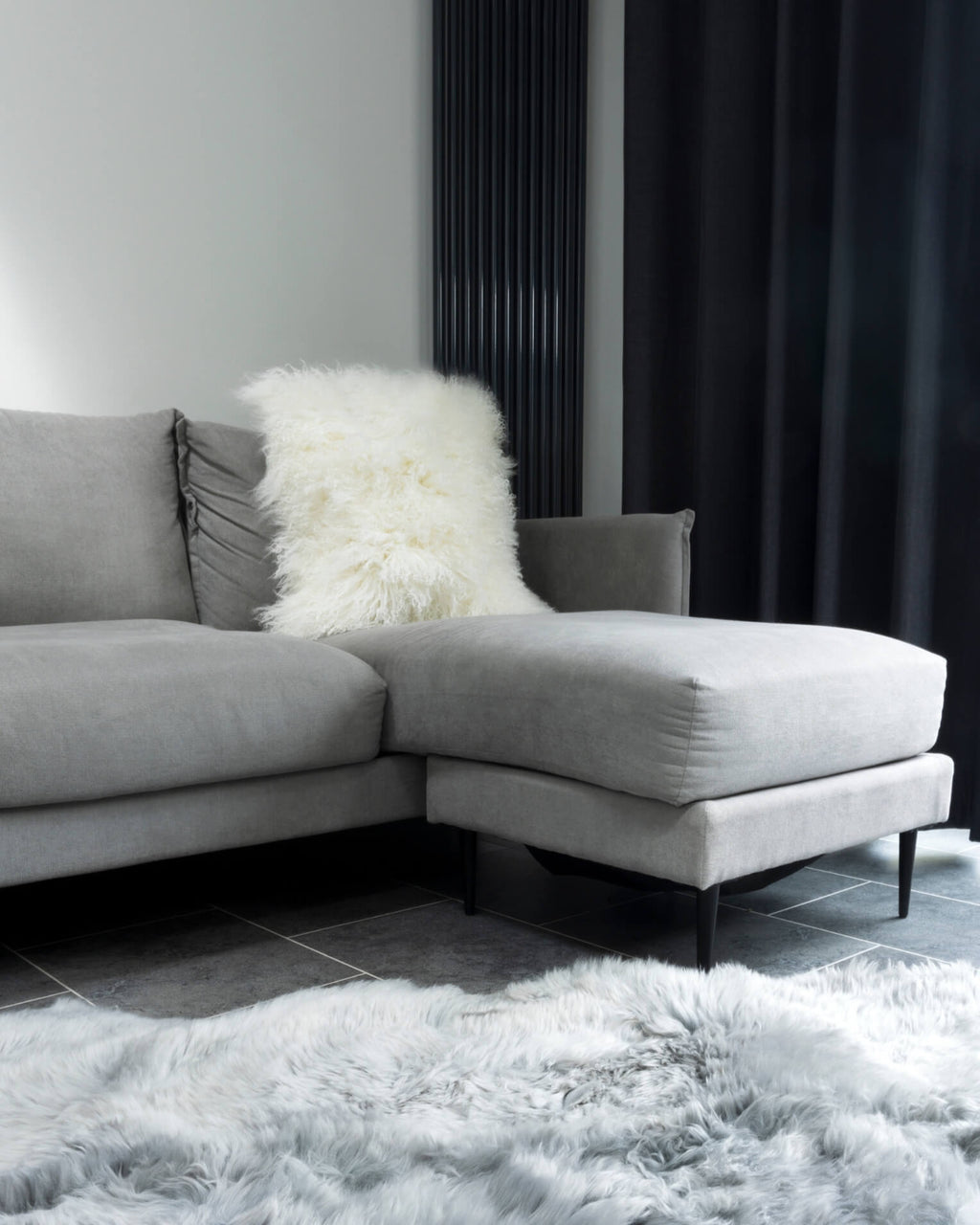 White mongolian sheepskin pillow on grey sofa