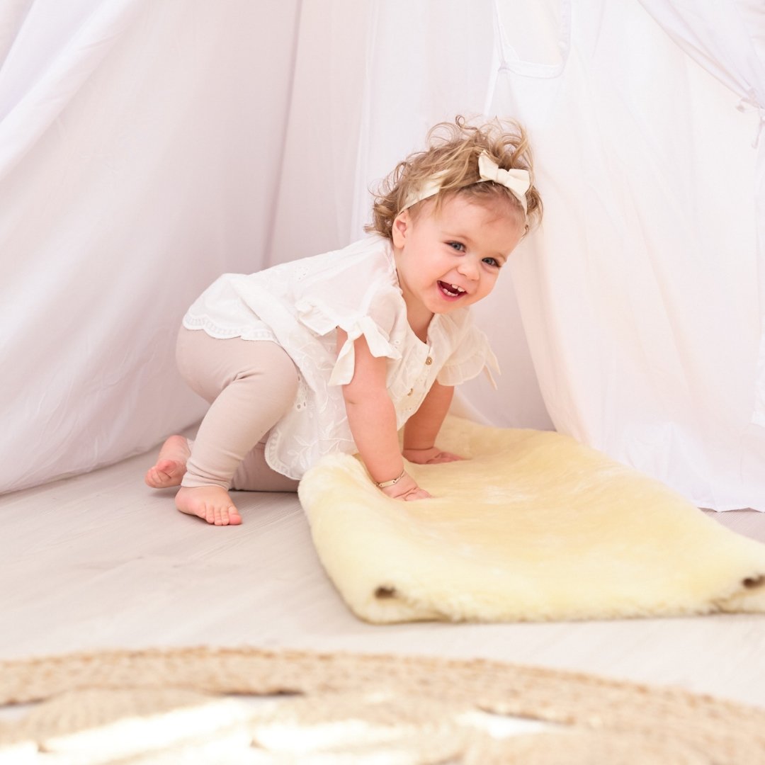 Sheepskin Baby Rug - Naturally Sheepskins baby girl climbing on sheepskin rug