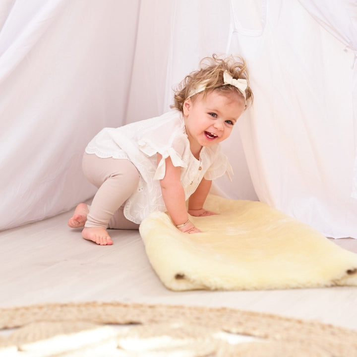 Sheepskin Baby Rug - Naturally Sheepskins baby girl climbing on sheepskin rug